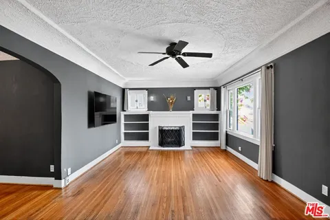 a living room with stainless steel appliances wooden floors and fireplace