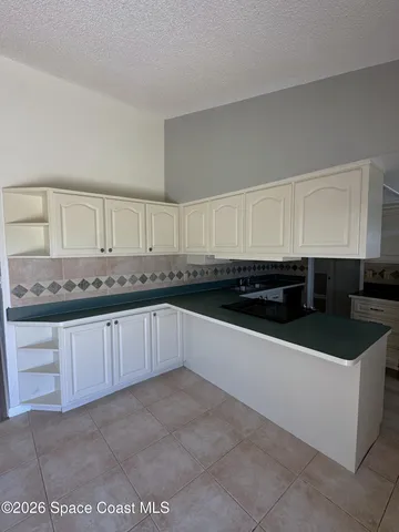 a kitchen with granite countertop a sink and a white cabinets
