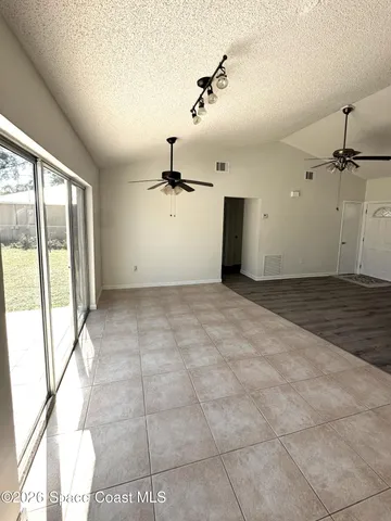a view of a room with a ceiling fan and window