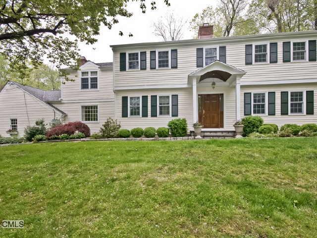 64 St Johns Road Wilton, CT 06897 - Photo 1 of 1 a front view of a house with a garden and porch