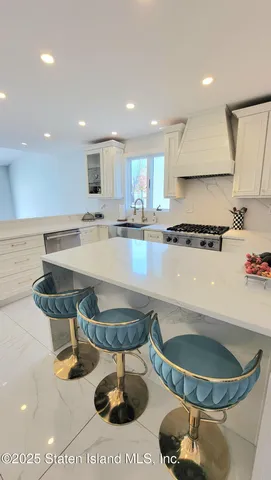 a kitchen with stainless steel appliances a stove a sink a microwave a refrigerator and cabinets