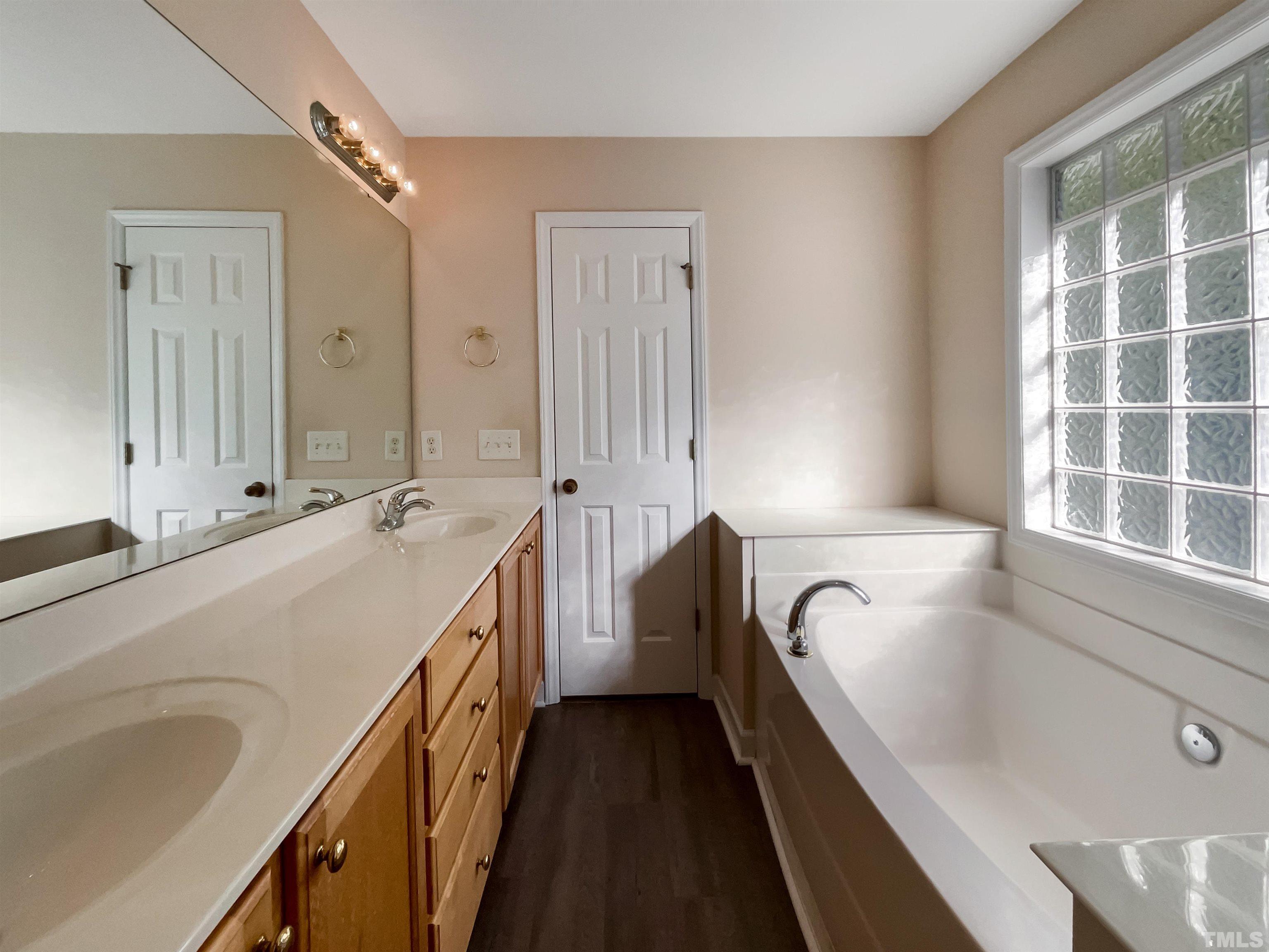 537 Seastone Street Raleigh, NC 27603 - Photo 6 of 25 a bathroom with a tub sink and mirror