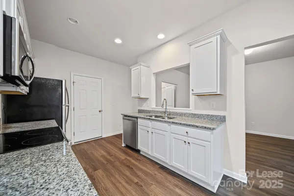 a spacious bathroom with a granite countertop sink a toilet and a mirror