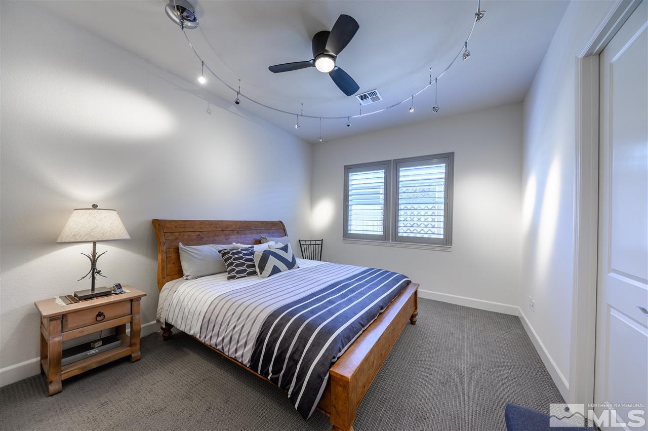 9745 Cardigan Bay Lane Reno, NV 89521 - Photo 16 of 25 a bedroom with a bed and a chandelier