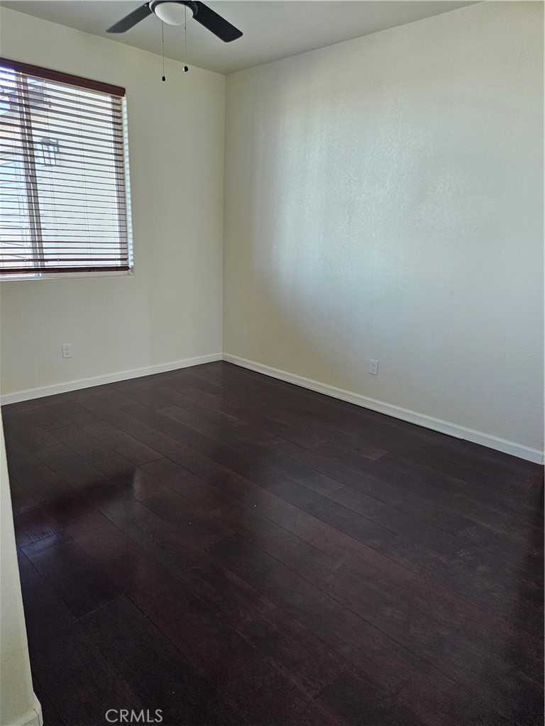 8630 Sahara Road Phelan, CA 92371 - Photo 11 of 21 an empty room with wooden floor and windows