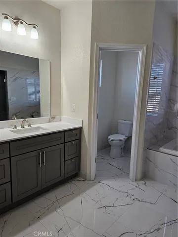 a spacious bathroom with a granite countertop sink toilet and shower