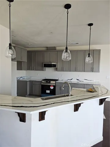 a kitchen with stainless steel appliances granite countertop a sink a stove and a refrigerator