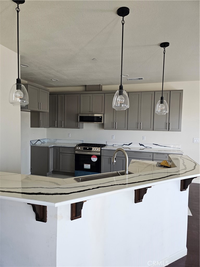 8630 Sahara Road Phelan, CA 92371 - Photo 7 of 21 a kitchen with stainless steel appliances granite countertop a sink a stove and a refrigerator