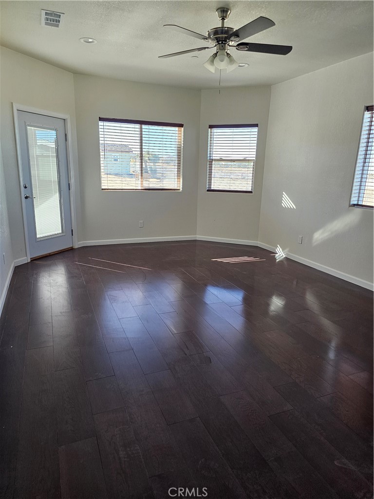 8630 Sahara Road Phelan, CA 92371 - Photo 10 of 21 a view of an empty room with wooden floor and a window