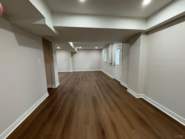 an empty room with wooden floor & windows