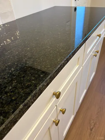 a large kitchen with stainless steel appliances kitchen island granite countertop a stove a sink dishwasher and a microwave oven with large wooden cabinets