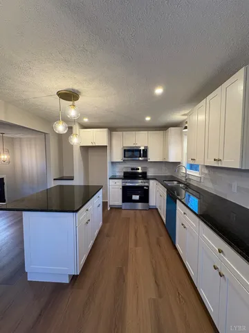 a kitchen with granite countertop a sink cabinets and window