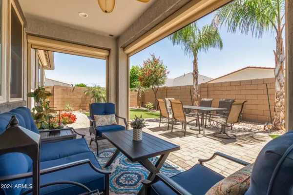 a view of a patio with table and chairs potted plants and floor to ceiling window