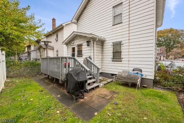 a view of a small house with backyard and sitting area