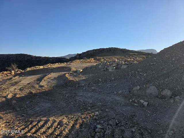 a view of mountain with sunset in background