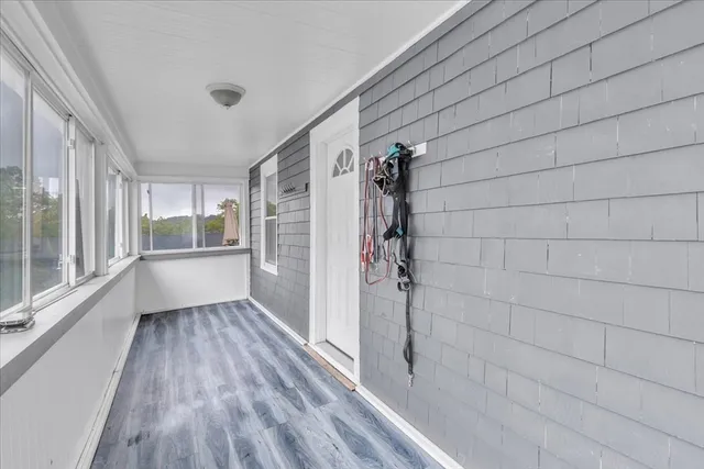 a bathroom with a wooden floor and a glass door