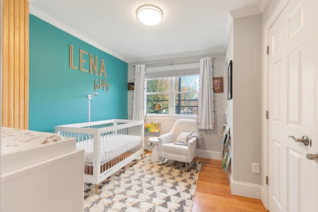19 Foster Street, Unit 19 Arlington, MA 02474 - Photo 19 of 33 a spacious bedroom with a bed and a window