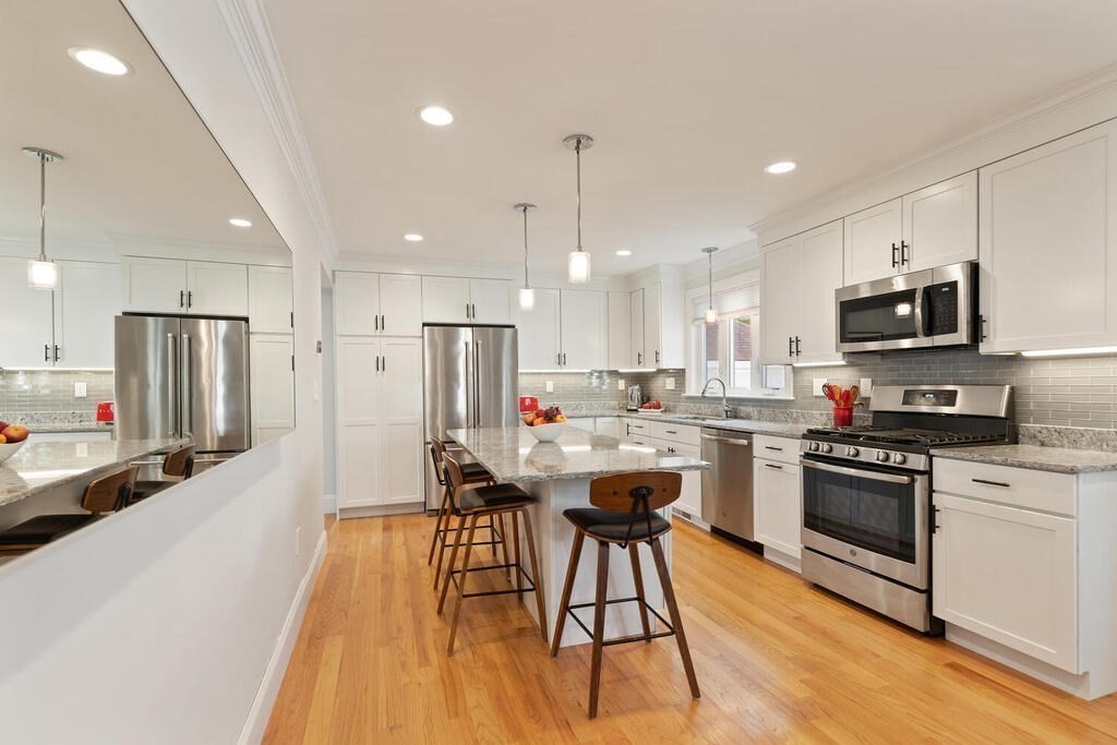 19 Foster Street, Unit 19 Arlington, MA 02474 - Photo 2 of 33 a kitchen with stainless steel appliances kitchen island a stove a sink a refrigerator and a microwave