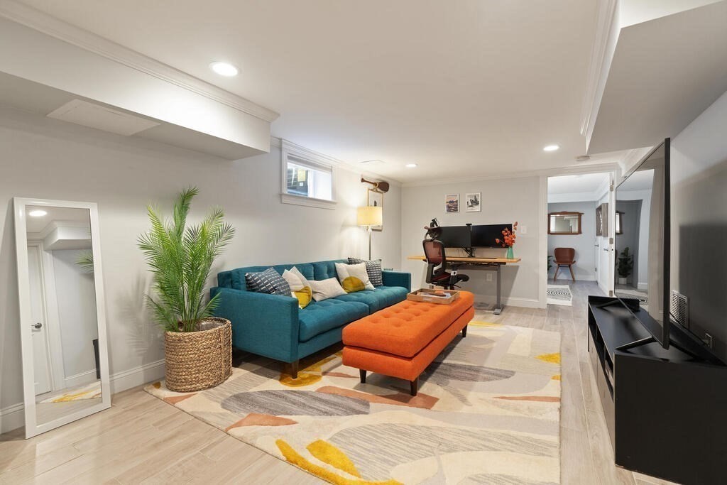 19 Foster Street, Unit 19 Arlington, MA 02474 - Photo 22 of 33 a living room with furniture a flat screen tv and a potted plant