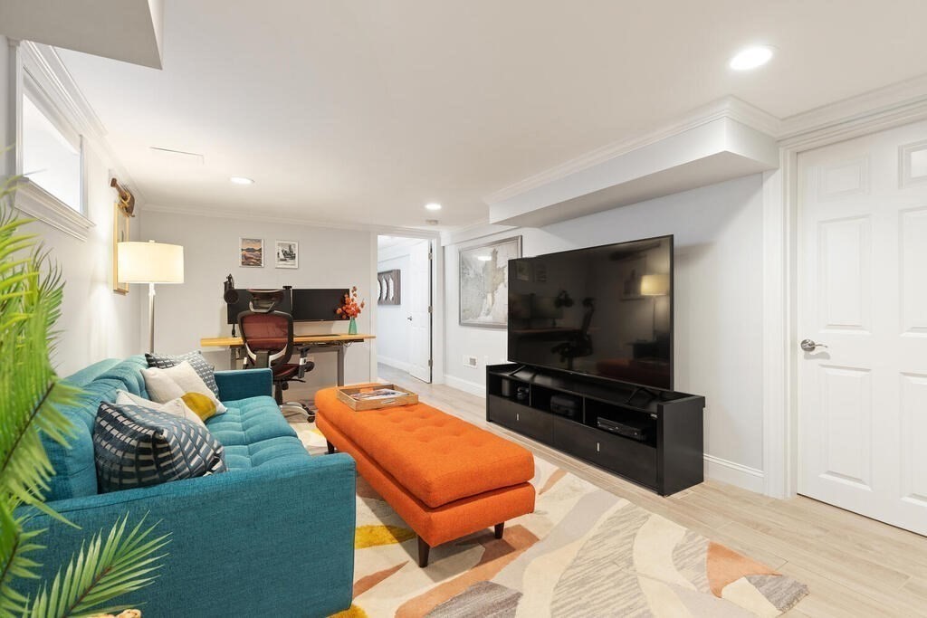 19 Foster Street, Unit 19 Arlington, MA 02474 - Photo 24 of 33 a living room with furniture and a flat screen tv