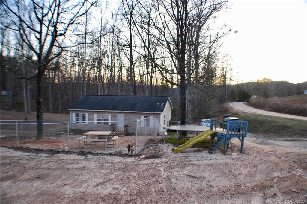 115 Cold Springs Drive Mill Spring, NC 28756 - Photo 2 of 19 a backyard of a house with fire pit and chairs