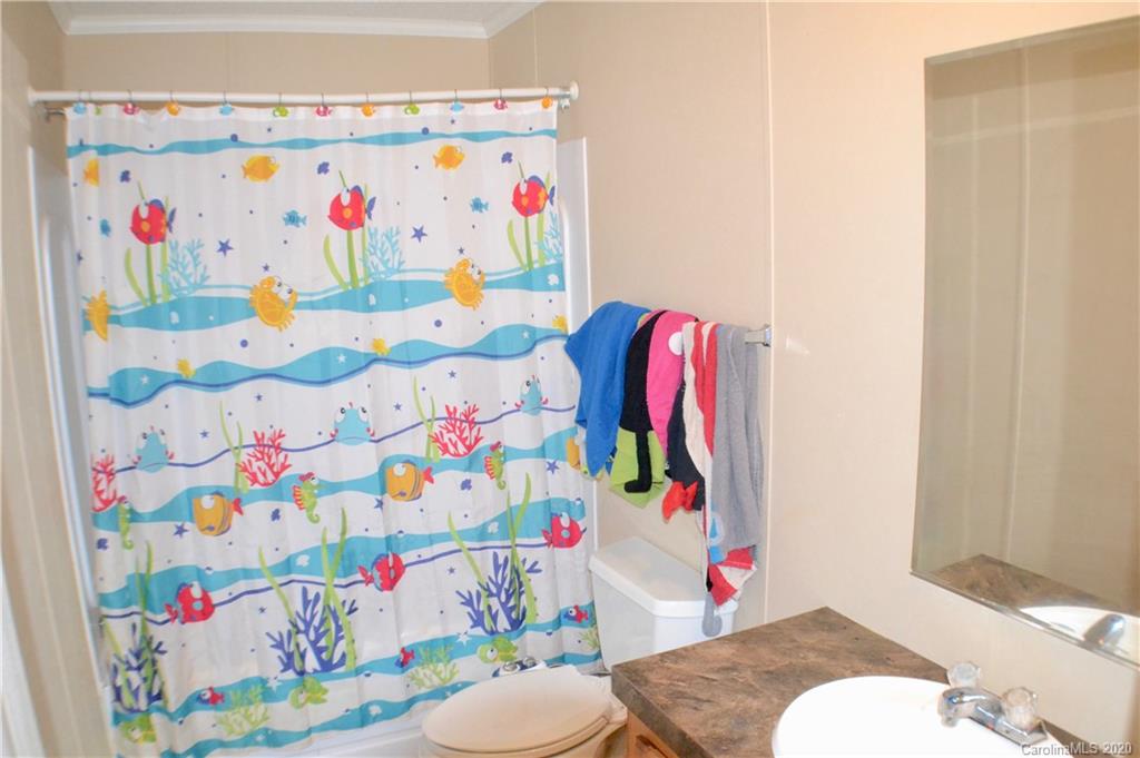 115 Cold Springs Drive Mill Spring, NC 28756 - Photo 14 of 19 a bathroom with a sink a toilet and curtain