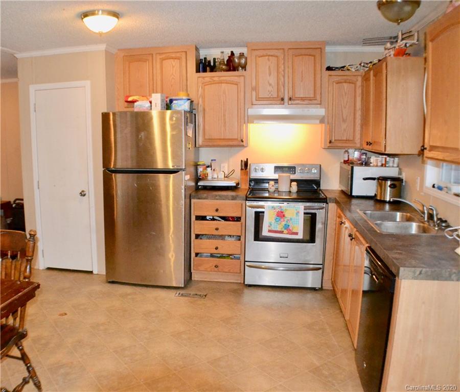 115 Cold Springs Drive Mill Spring, NC 28756 - Photo 5 of 19 a kitchen with refrigerator a stove a washer and dryer