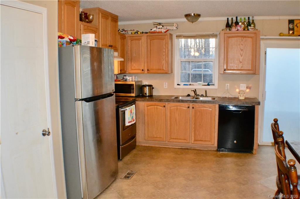 115 Cold Springs Drive Mill Spring, NC 28756 - Photo 6 of 19 a kitchen with stainless steel appliances granite countertop a refrigerator a sink a stove and island