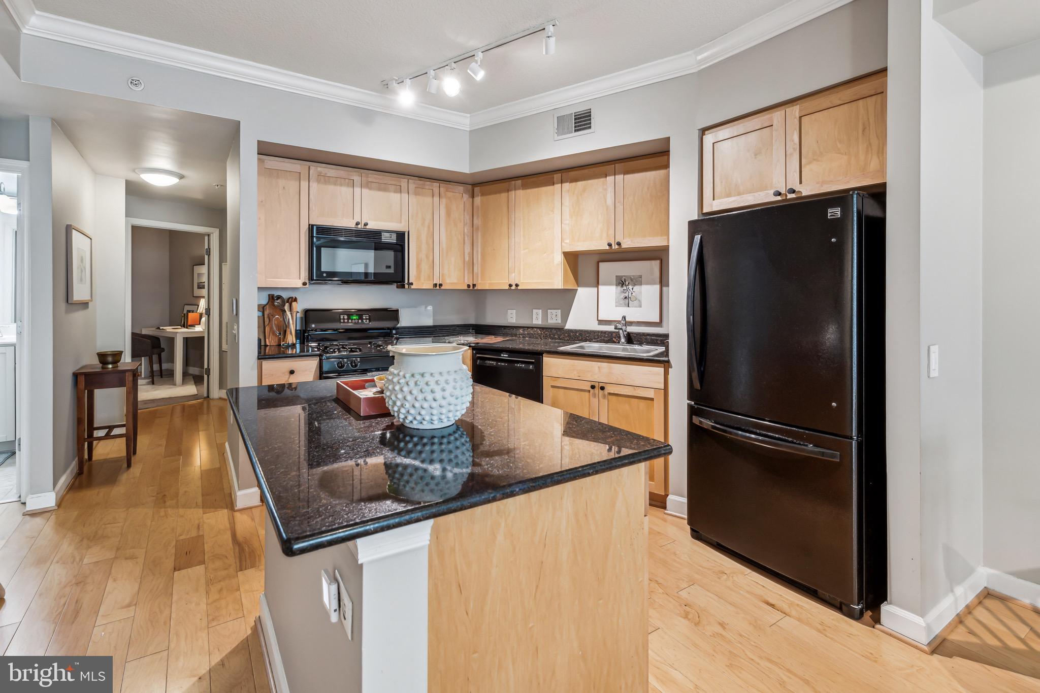 1441 Rhode Island Avenue Northwest, Unit 412 Washington, DC 20005 - Photo 15 of 37 a kitchen with stainless steel appliances granite countertop a refrigerator a stove a sink a dining table and chairs