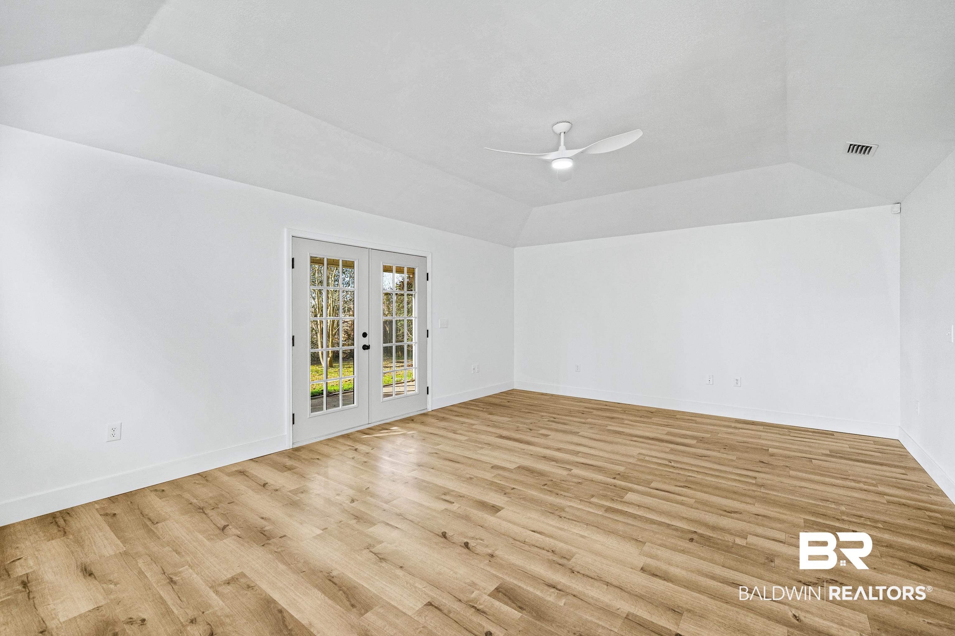 9243 Brookshire Loop Daphne, AL 36526 - Photo 7 of 26 Empty room with french doors, lofted ceiling, and light hardwood / wood-style flooring