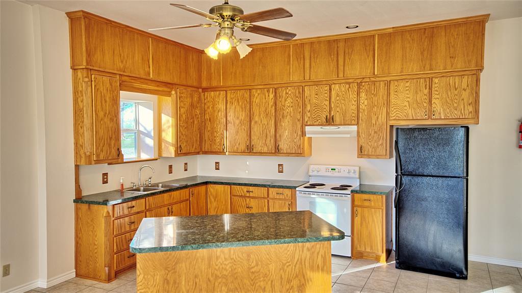 306 Dye Church Road St. Jo, TX 76265 - Photo 12 of 29 a kitchen with a sink a stove and a refrigerator