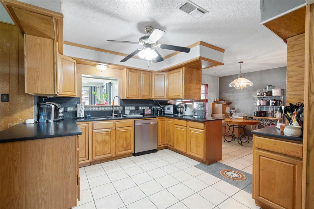 2200 Southeast 26th Avenue Mineral Wells, TX 76067 - Photo 19 of 28 a kitchen with stainless steel appliances granite countertop a refrigerator a sink dishwasher a oven with white cabinets and countertops