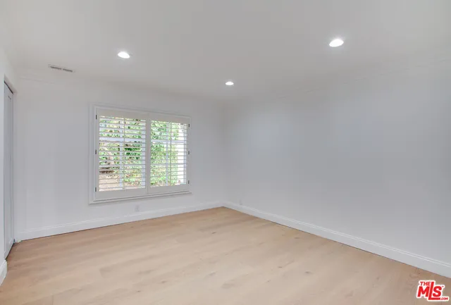an empty room with a window and a kitchen