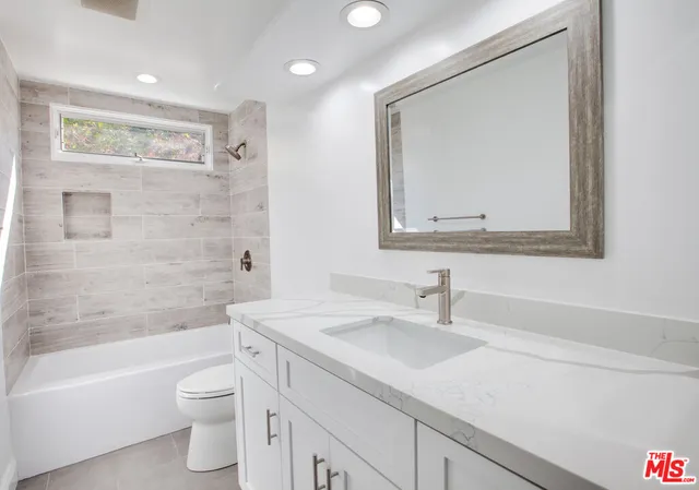 a view of a big room with wooden floor and windows