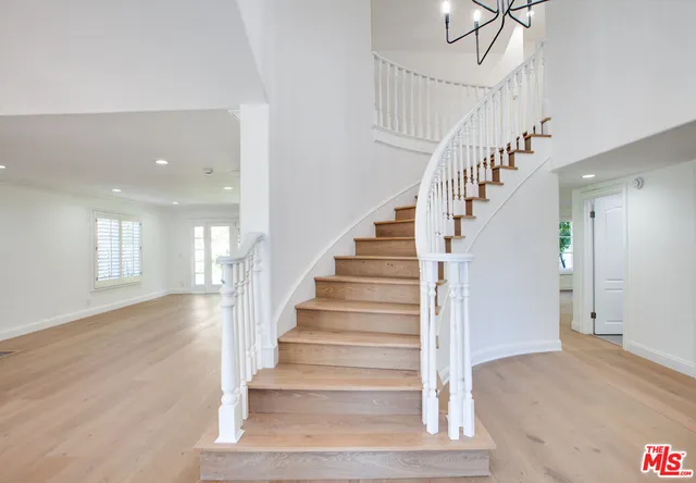 a view of an entryway with wooden floor and staircase