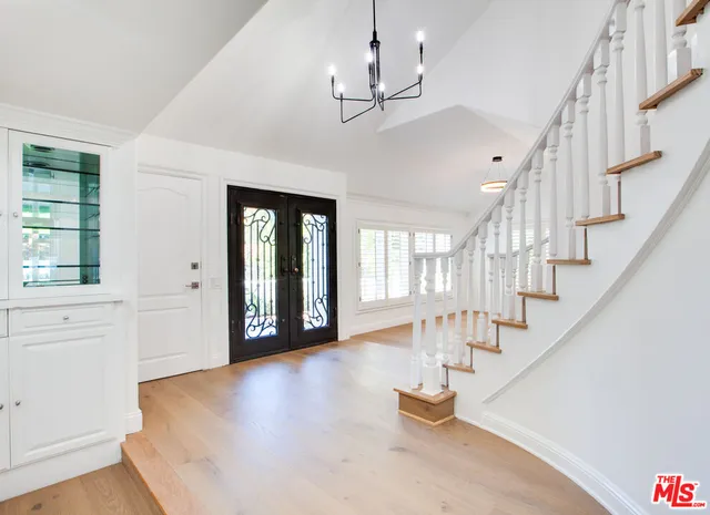 an empty room with wooden floor fireplace and windows