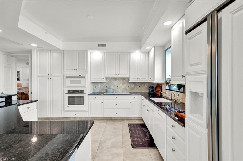 295 Grande Way, Unit 306 Naples, FL 34110 - Photo 13 of 48 a kitchen with stainless steel appliances granite countertop a refrigerator and white cabinets