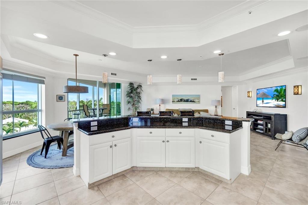 295 Grande Way, Unit 306 Naples, FL 34110 - Photo 14 of 48 a kitchen with granite countertop a sink and white cabinets