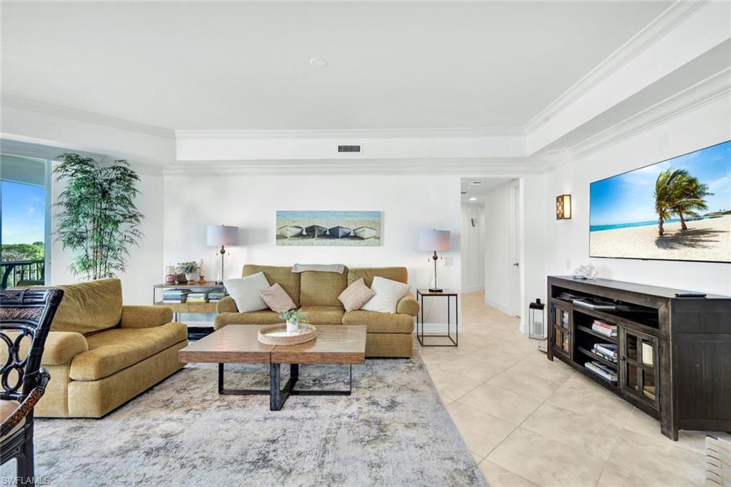 295 Grande Way, Unit 306 Naples, FL 34110 - Photo 18 of 48 a living room with furniture and a flat screen tv