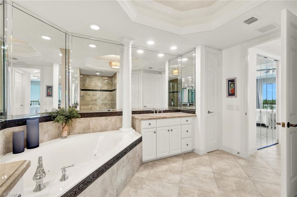 295 Grande Way, Unit 306 Naples, FL 34110 - Photo 23 of 48 a large spacious bathroom with a granite countertop tub sink shower and a mirror