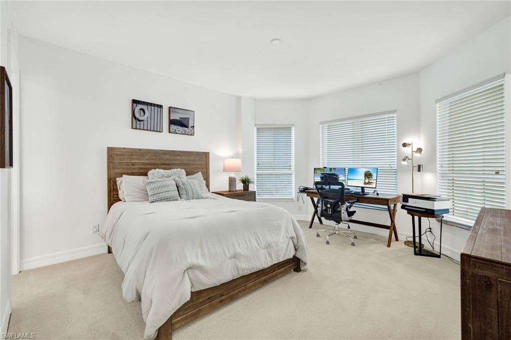 295 Grande Way, Unit 306 Naples, FL 34110 - Photo 24 of 48 a bedroom with a bed a table and chair