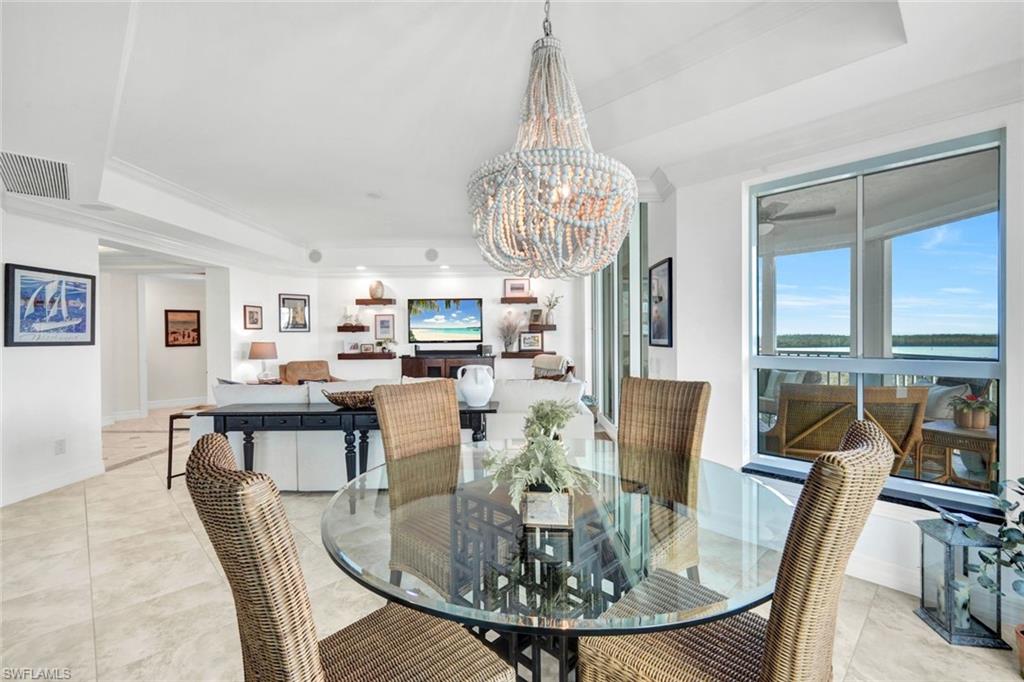 295 Grande Way, Unit 306 Naples, FL 34110 - Photo 7 of 48 a view of a dining room with furniture large windows and wooden floor