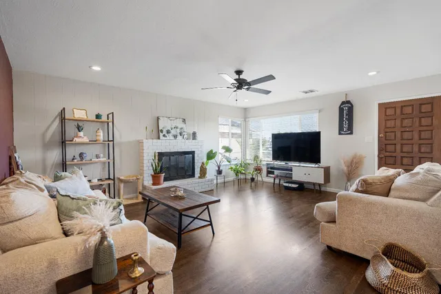 a living room with furniture a flat screen tv and a fireplace
