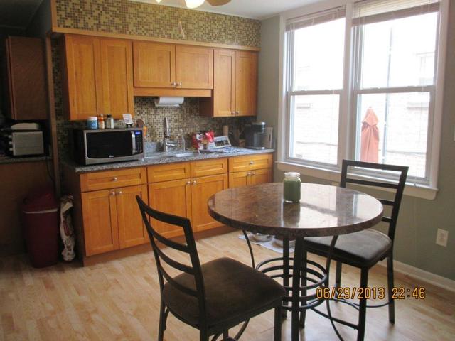 2829 South Lowe Avenue Chicago, IL 60616 - Photo 3 of 11 a kitchen with stainless steel appliances granite countertop a table chairs and a refrigerator