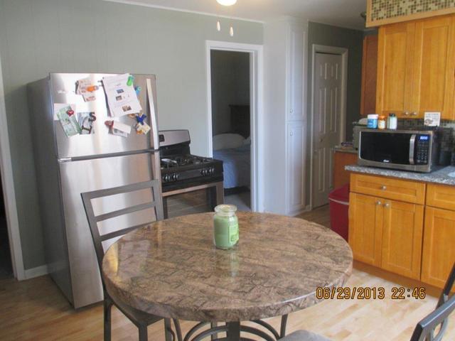 2829 South Lowe Avenue Chicago, IL 60616 - Photo 4 of 11 a kitchen with stainless steel appliances a dining table chairs and granite counter tops