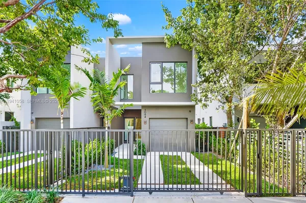 a view of a house with a small yard and wooden fence