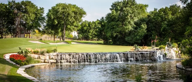 a view of a swimming pool with a lawn chairs and plants