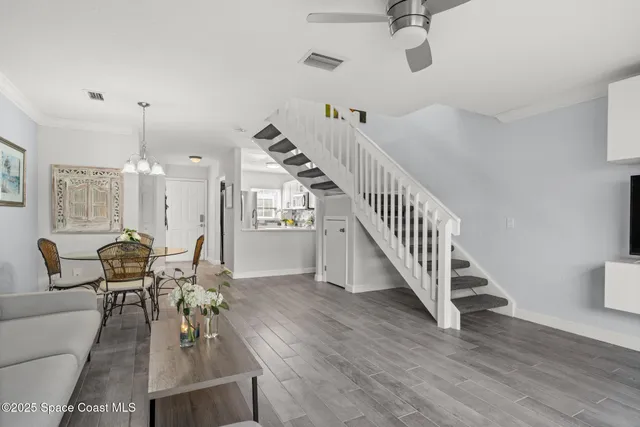 a living room with couches chairs and kitchen view with wooden floor