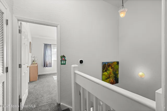 a view of a hallway with wooden floor and front door