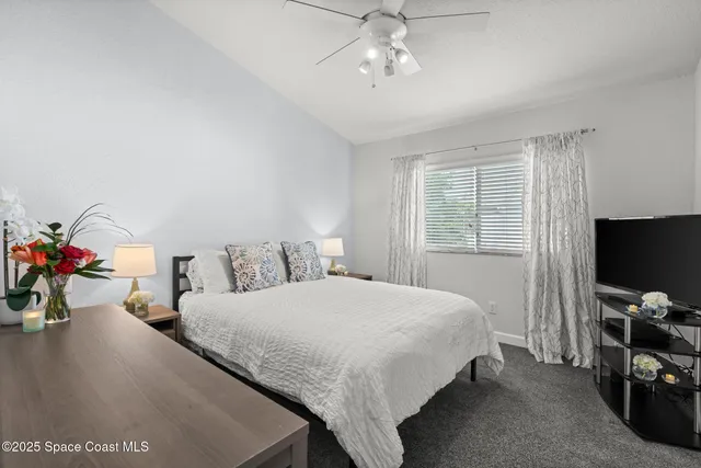 a bedroom with a bed and a flat tv screen on the dresser
